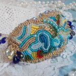 Pulsera Mariposa de Oro Azul bordada con cristales de Swarovski; gotas lisas, facetas, cuentas de semillas y un cierre de Oro Fino de 14 quilates